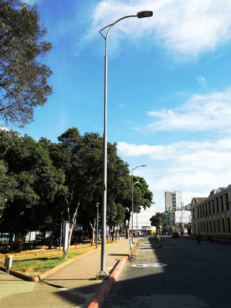 Poste metalico de alumbrado publico instalado en via urbana con luminaria LED